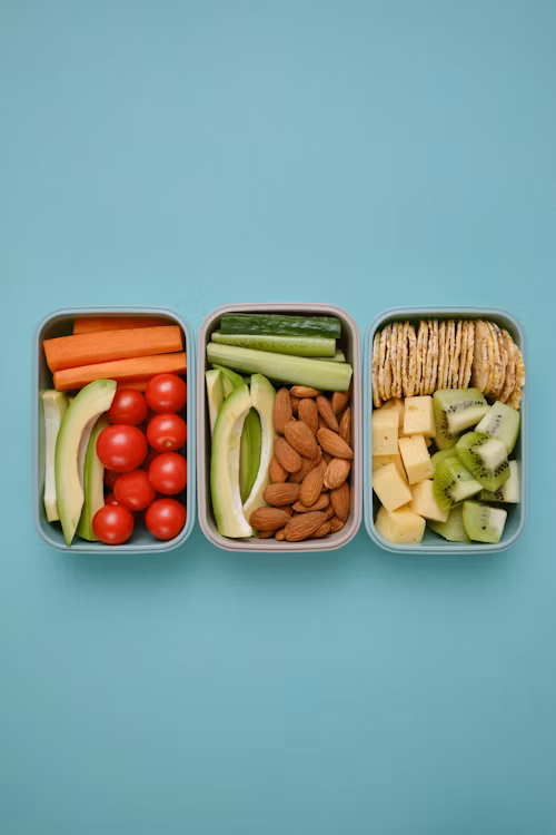 Zdrava užina sa svežim voćem, orašastim plodovima i avokadom na drvenom stolu